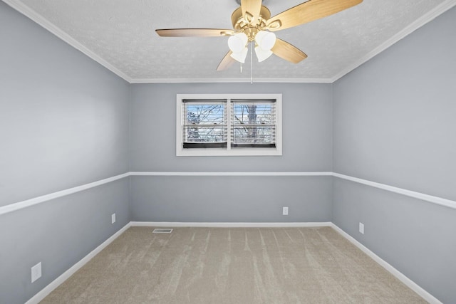 spare room featuring light carpet, a textured ceiling, ceiling fan, and ornamental molding