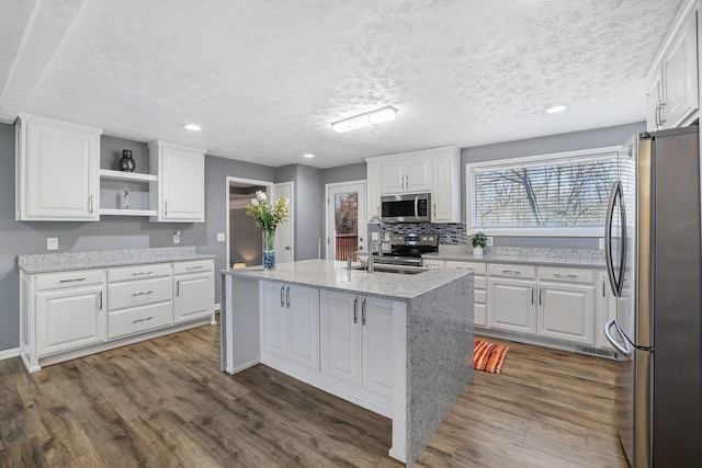 kitchen with white cabinets, sink, an island with sink, and stainless steel appliances