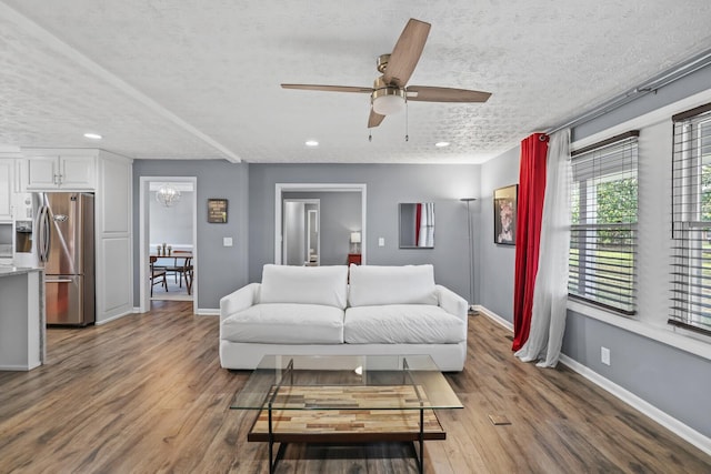 living room featuring a textured ceiling, hardwood / wood-style flooring, and ceiling fan