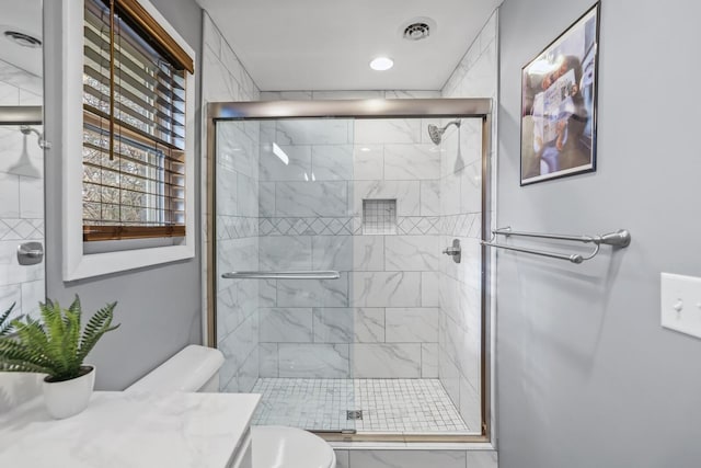 bathroom with vanity, a shower with shower door, and toilet