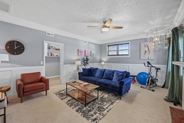 living room with carpet, a textured ceiling, ceiling fan, and crown molding