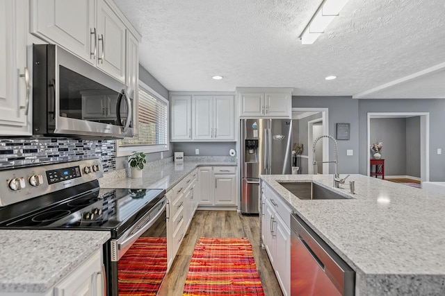 kitchen featuring white cabinets, appliances with stainless steel finishes, a textured ceiling, and sink