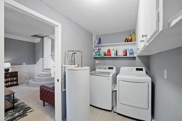 laundry area featuring cabinets, ornamental molding, a textured ceiling, gas water heater, and washing machine and dryer