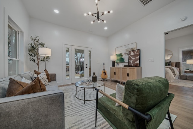 living room featuring a chandelier and light wood-type flooring