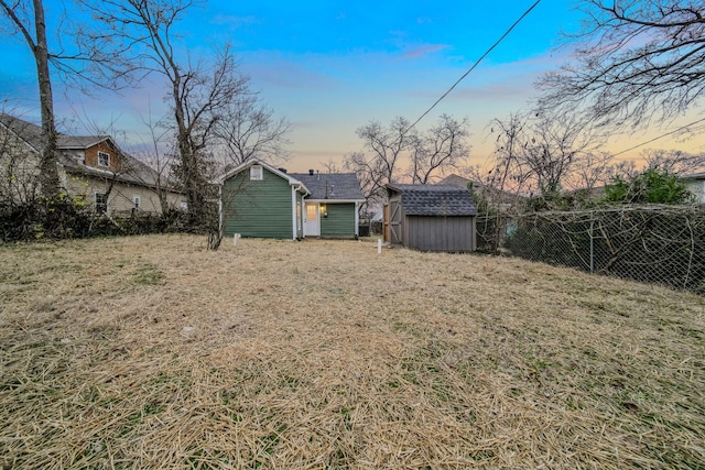 yard at dusk featuring a storage shed