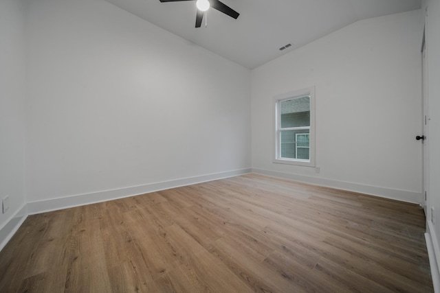 empty room with ceiling fan, light wood-type flooring, and lofted ceiling