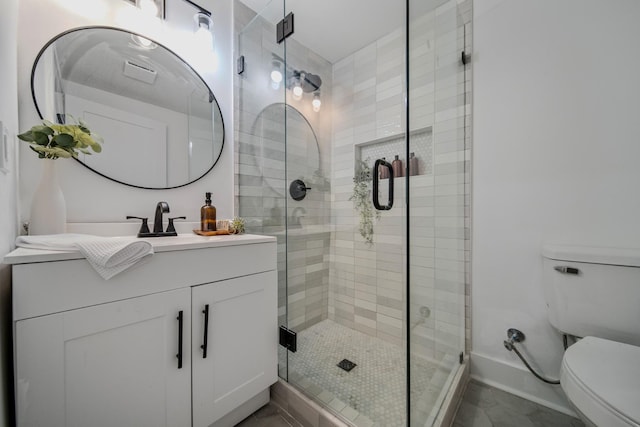 bathroom with an enclosed shower, vanity, and toilet