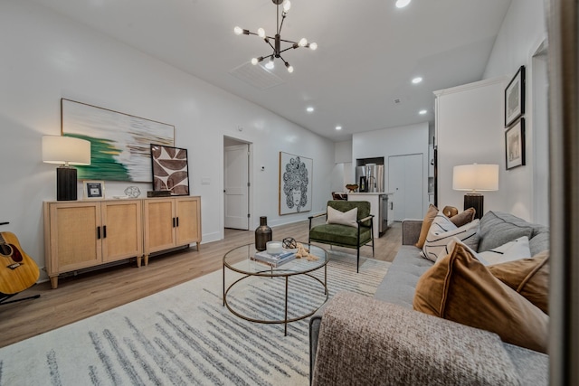 living room with light hardwood / wood-style flooring and a notable chandelier