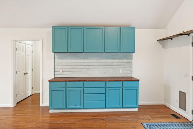 kitchen with blue cabinetry and dark hardwood / wood-style flooring