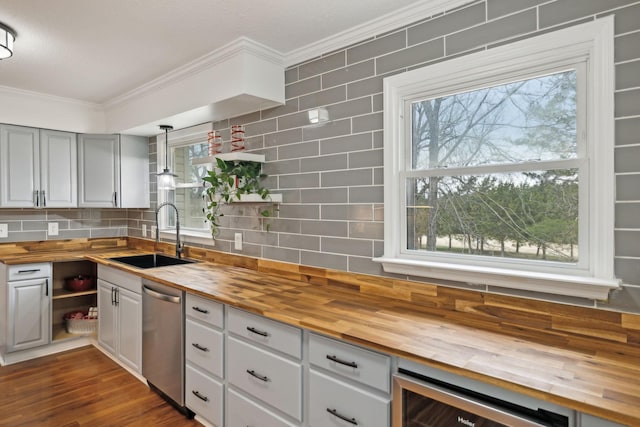 kitchen featuring stainless steel dishwasher, beverage cooler, butcher block counters, and sink