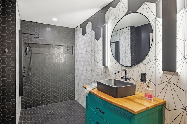 bathroom with vanity, tile walls, and a tile shower