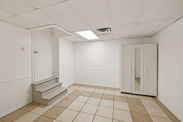 tiled spare room featuring a paneled ceiling