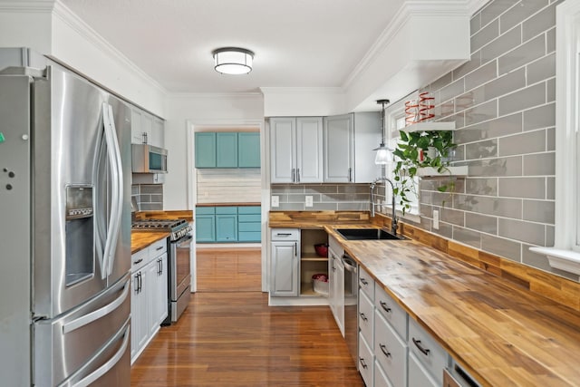 kitchen featuring wood counters, sink, decorative backsplash, and appliances with stainless steel finishes