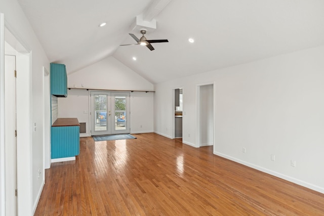 unfurnished living room with hardwood / wood-style flooring, ceiling fan, vaulted ceiling, and french doors