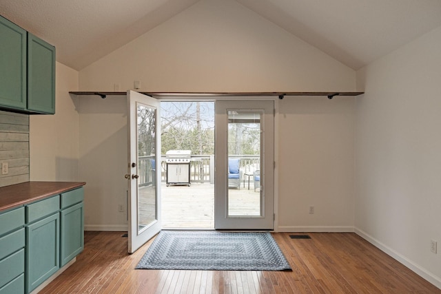 doorway with vaulted ceiling and light hardwood / wood-style floors