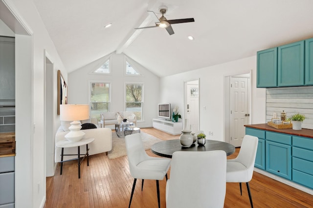 dining room featuring ceiling fan, light wood-type flooring, and vaulted ceiling with beams