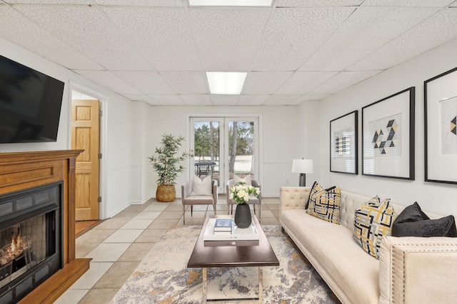 tiled living room with a paneled ceiling and french doors