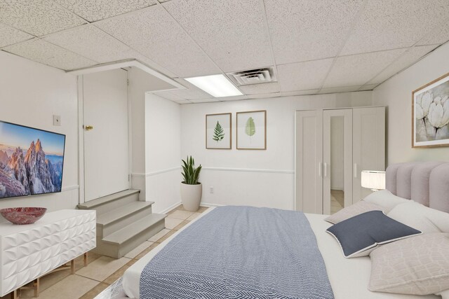 tiled bedroom featuring a paneled ceiling