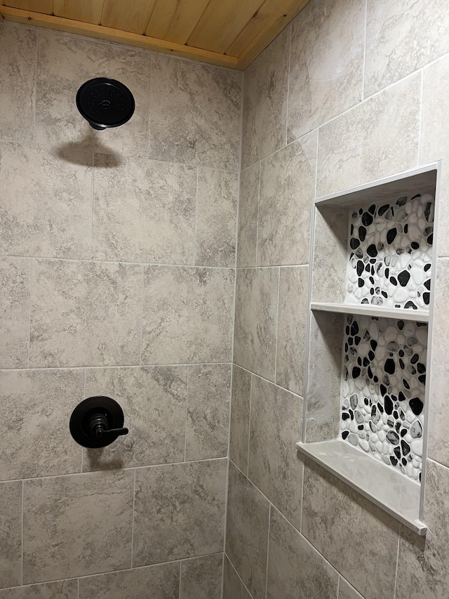 interior details featuring a tile shower