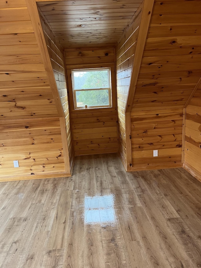 additional living space with hardwood / wood-style floors, wood ceiling, and wood walls