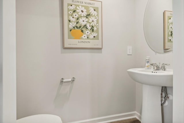 half bathroom with toilet and baseboards