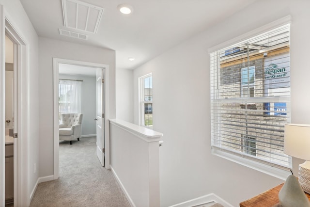 corridor featuring an upstairs landing, carpet flooring, visible vents, and baseboards