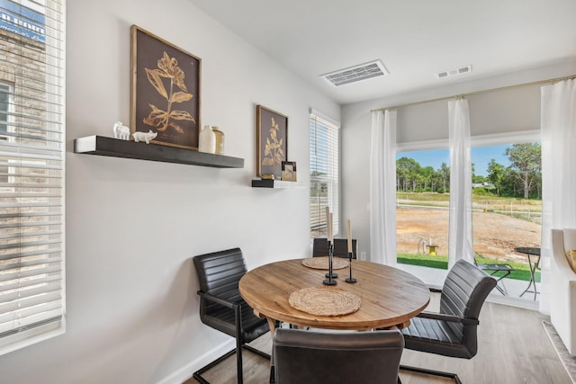 dining space with visible vents, baseboards, and wood finished floors