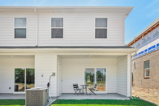 rear view of property with central air condition unit and a patio