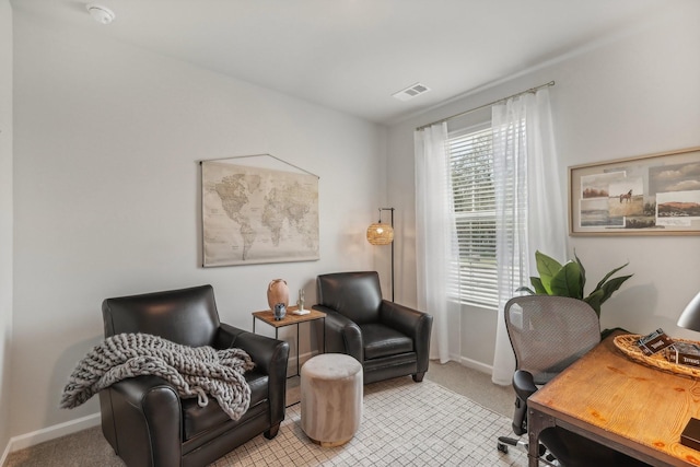 office with visible vents, baseboards, and light colored carpet