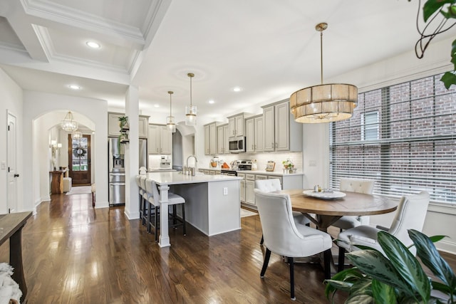 dining area featuring beam ceiling, sink, dark wood-type flooring, and coffered ceiling