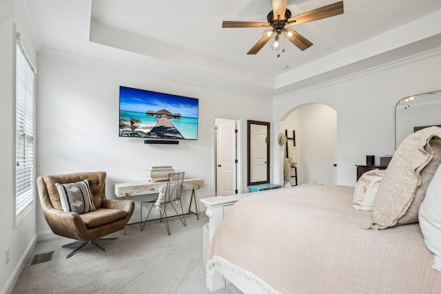 bedroom with light colored carpet, a raised ceiling, ceiling fan, and crown molding