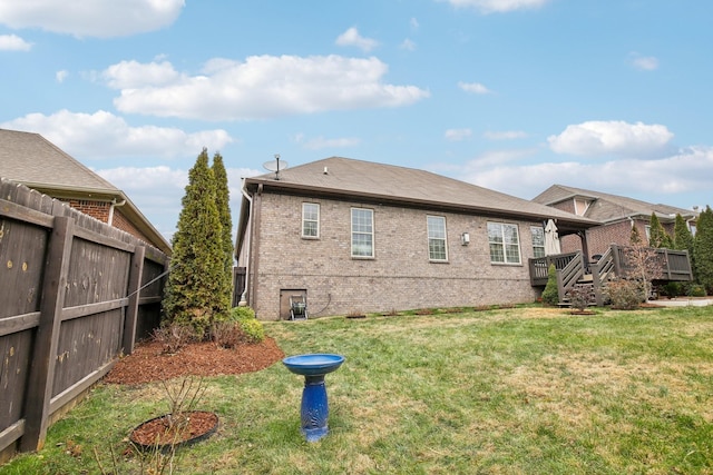 rear view of property with a wooden deck and a yard