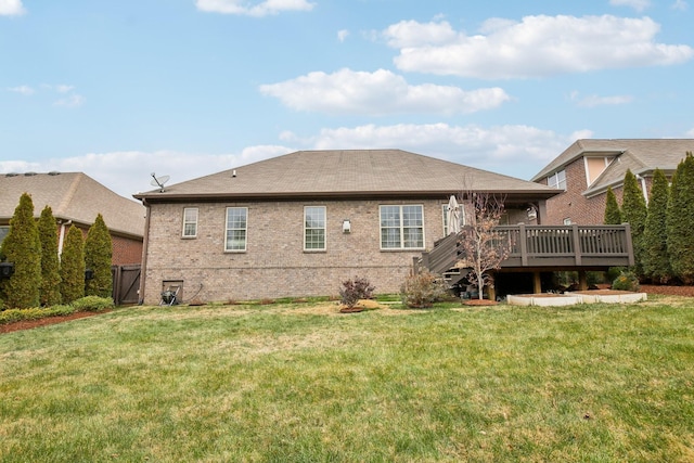 rear view of house featuring a lawn and a deck