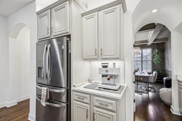 kitchen featuring beam ceiling, dark wood-type flooring, coffered ceiling, stainless steel refrigerator with ice dispenser, and decorative backsplash