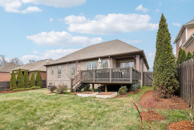 rear view of house featuring a deck and a lawn