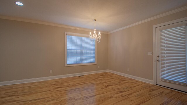 empty room featuring light hardwood / wood-style floors, ornamental molding, and a chandelier