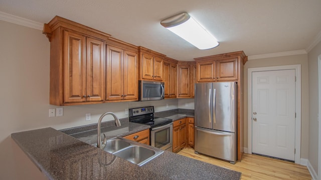 kitchen featuring light wood-type flooring, stainless steel appliances, crown molding, and sink