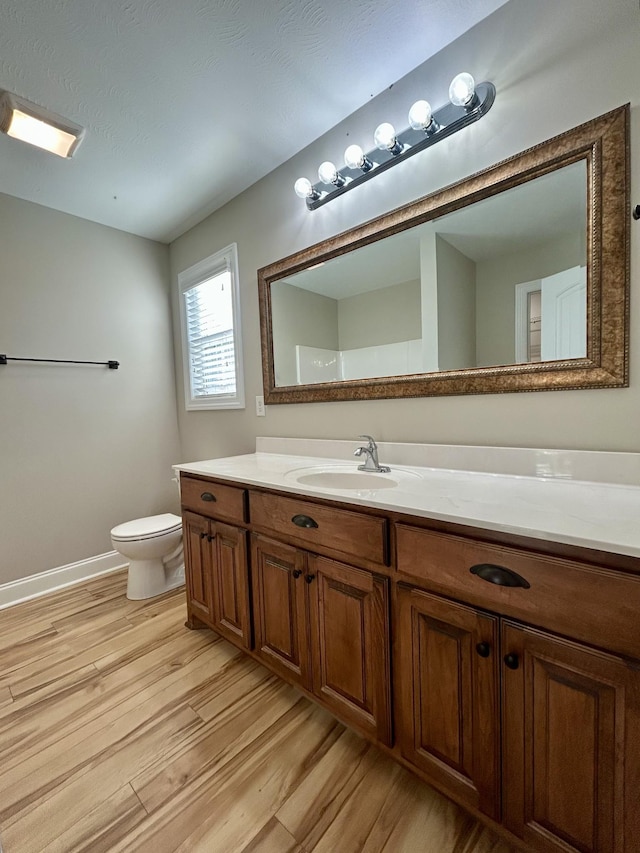 bathroom featuring vanity, toilet, and wood-type flooring