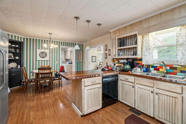 kitchen with sink, hanging light fixtures, black dishwasher, wooden counters, and kitchen peninsula