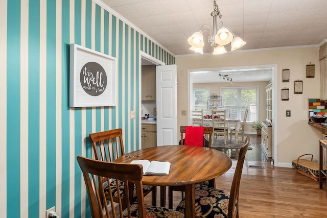 dining area featuring a chandelier, hardwood / wood-style flooring, and ornamental molding