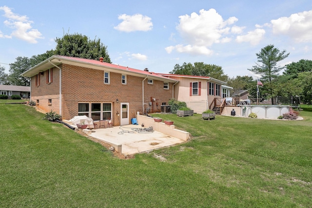 rear view of house featuring a patio and a lawn