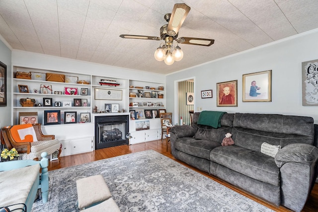 living room with crown molding, built in features, and hardwood / wood-style flooring