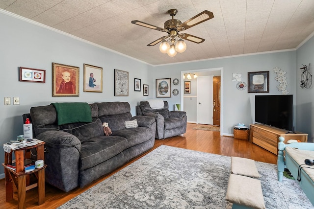 living room with crown molding, ceiling fan, and wood-type flooring