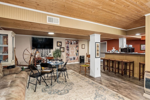 dining space with bar area, crown molding, wood ceiling, and wood-type flooring