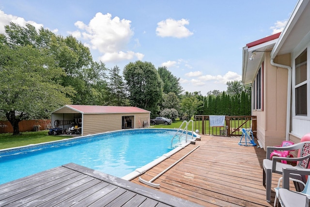 view of swimming pool featuring a deck, an outdoor structure, and a lawn