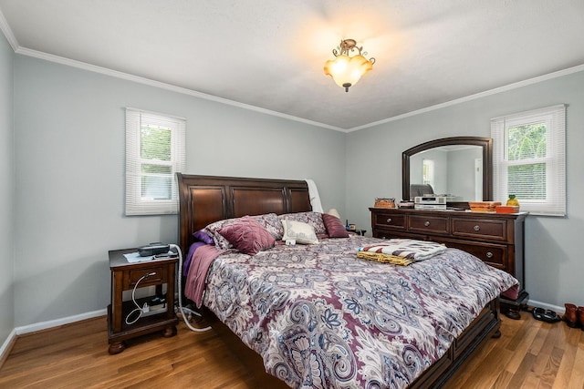 bedroom with multiple windows, hardwood / wood-style floors, and ornamental molding