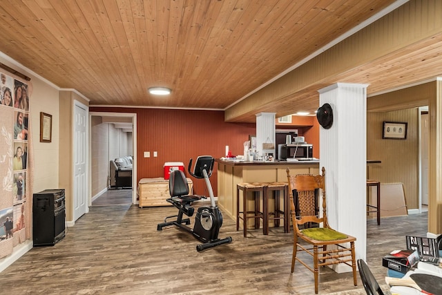 workout area featuring hardwood / wood-style flooring, wooden ceiling, ornamental molding, and indoor bar