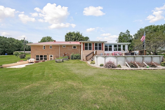 back of property featuring a sunroom and a yard