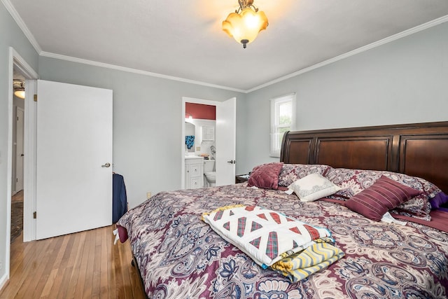 bedroom with light hardwood / wood-style floors, ensuite bath, and crown molding