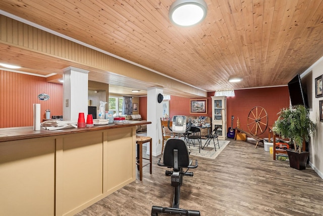 workout area featuring hardwood / wood-style floors, ornamental molding, and wood ceiling